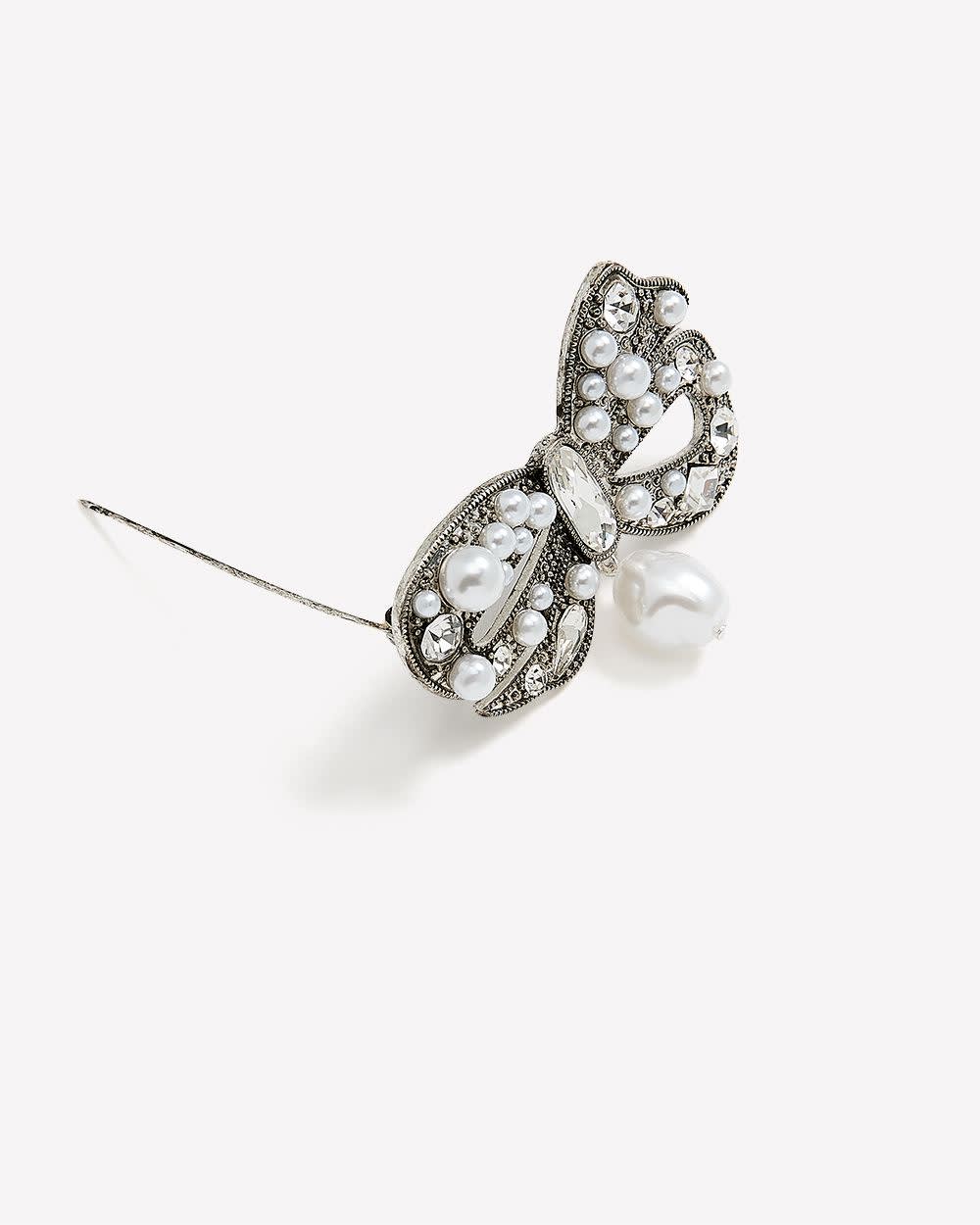 Broche argentée en forme de boucle avec perles