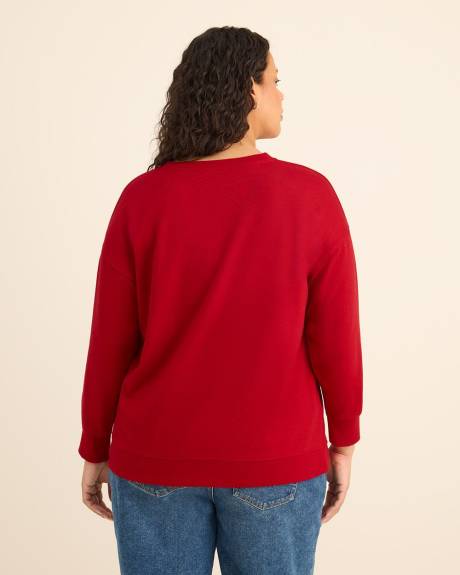 Pull rouge à col rond avec imprimé du Grinch