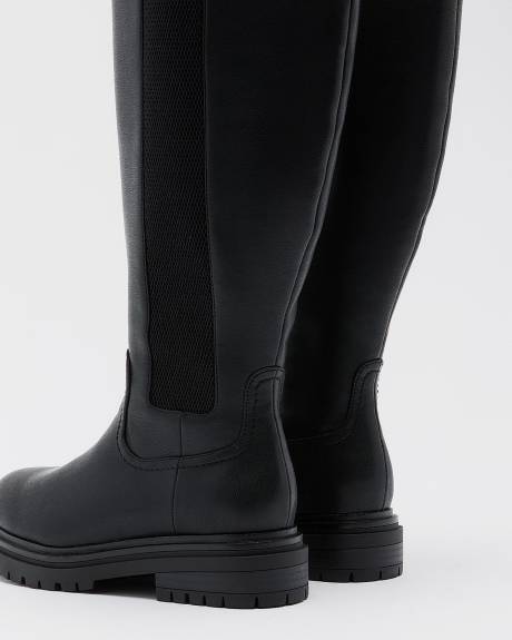 Bottes hautes noires à talon plat et bande élastique sur le côté, pied très large