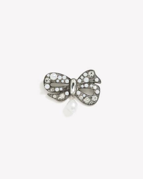 Broche argentée en forme de boucle avec perles