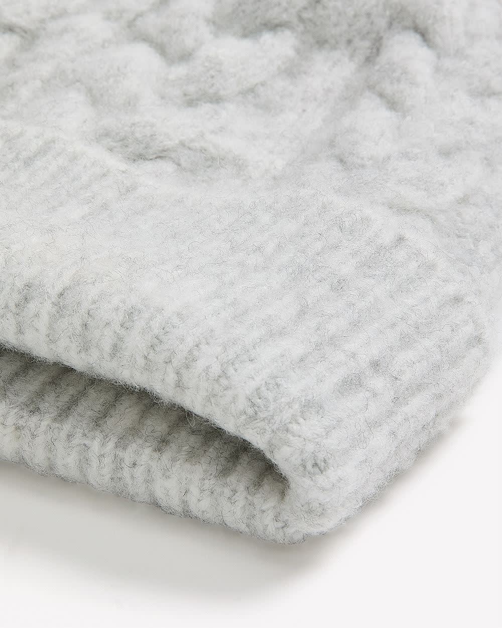 Bonnet à revers en laine à mailles torsadées avec pompon Bonnet à revers en laine à mailles torsadées avec pompon