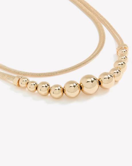 Collier doré court à deux chaînes avec billes